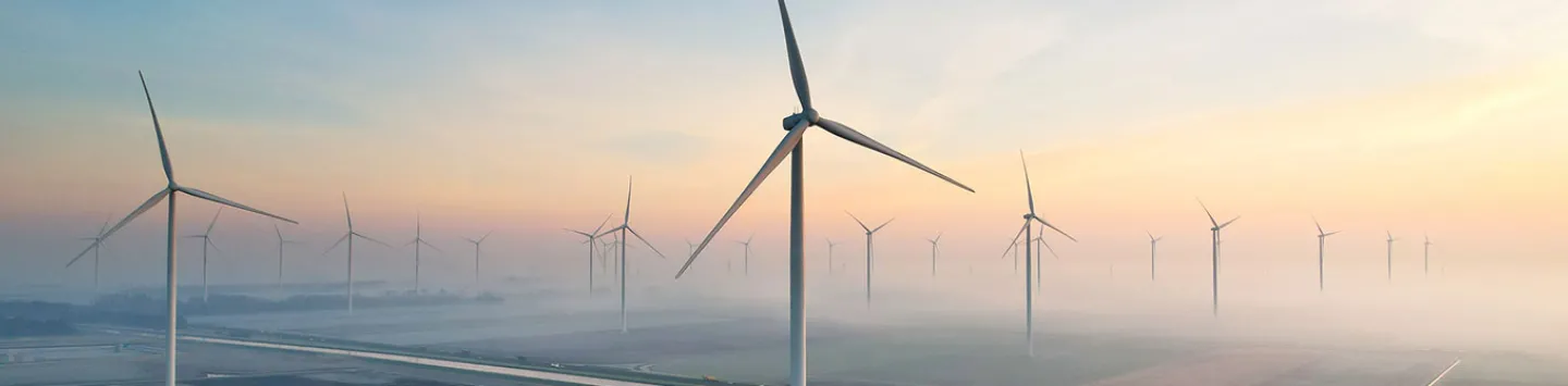 Solar energy field and wind turbines seen from the air during sunrise